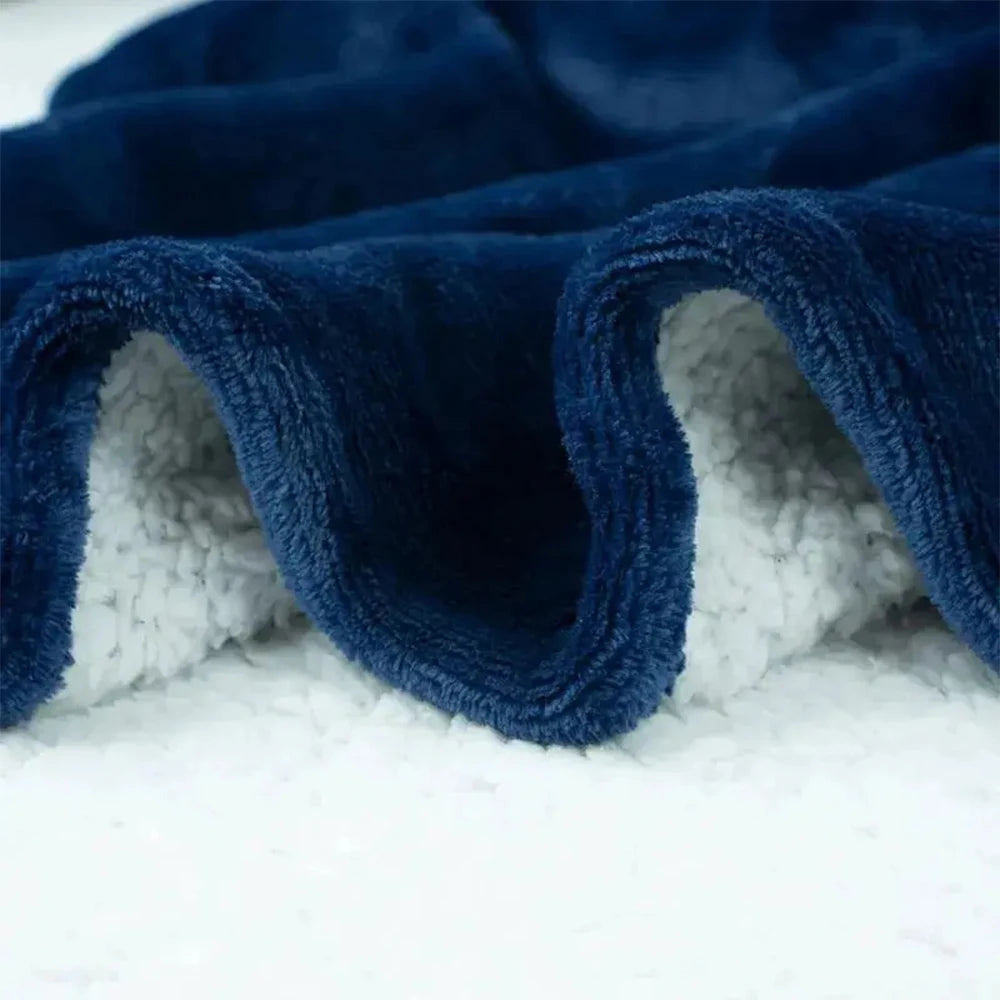 Gros plan sur la polaire bleu marine et le sherpa blanc du sweat plaid extra long