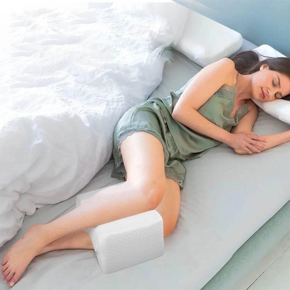 Coussin genoux glissé entre les genoux d’une personne endormie sur le côté (coloris blanc)