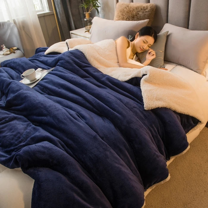 Plaid sherpa double face bleu nuit sur un lit