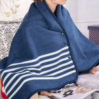 Plaid châle bleu marine rayé porté sur les épaules