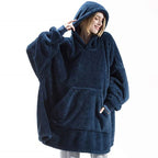 Sweat plaid teddy bleu nuit porté, capuche relevée, une main dans la poche kangourou